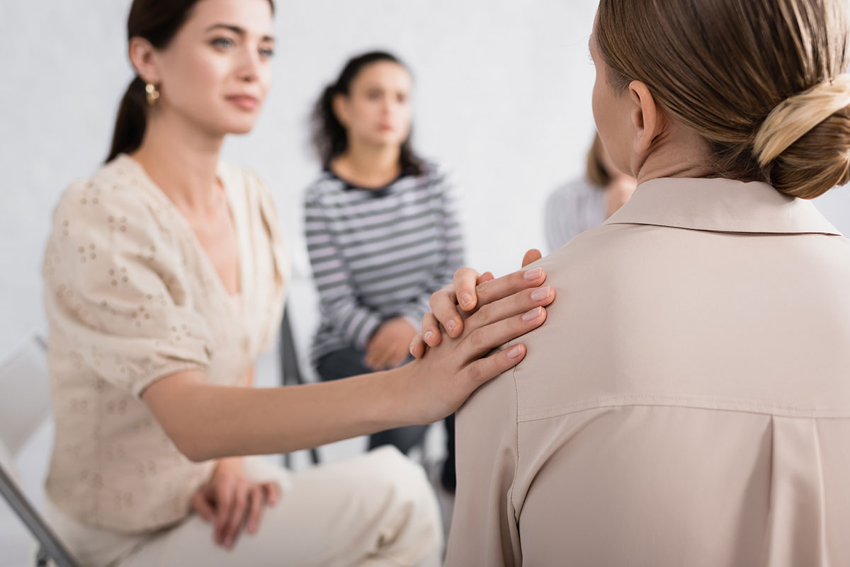 woman comforting client in group session